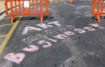 "Art Means Business" written in chalk on pavement